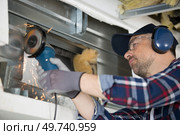 sparks flying as builder uses angle grinder. Стоковое фото, агентство Ingram Publishing / Фотобанк Лори