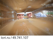 Man and woman looking through stack of metal reinforcing bars. Стоковое фото, агентство Ingram Publishing / Фотобанк Лори