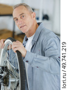 senior man checking bike wheel. Стоковое фото, агентство Ingram Publishing / Фотобанк Лори