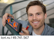 happy young man using levelling tool. Стоковое фото, агентство Ingram Publishing / Фотобанк Лори