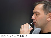 man holding an electronic cigarette. Стоковое фото, агентство Ingram Publishing / Фотобанк Лори