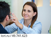 female optician fitting glasses onto male patient. Стоковое фото, агентство Ingram Publishing / Фотобанк Лори
