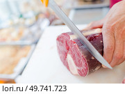 a butcher is slicing beef. Стоковое фото, агентство Ingram Publishing / Фотобанк Лори