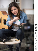emotional woman blogger with an acoustic guitar. Стоковое фото, агентство Ingram Publishing / Фотобанк Лори
