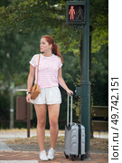 young woman waiting on a traffic light with baggage. Стоковое фото, агентство Ingram Publishing / Фотобанк Лори