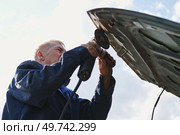Car body shop. Repair man processes the welding seam using an angle grinder on replaced car part. Professional Body master grind old paint and rust. Rust damage. Rusting car. Hands with tool close-up. Стоковое фото, фотограф Марина Демидюк / Фотобанк Лори
