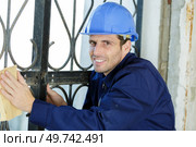 a man working sanding outdoors. Стоковое фото, агентство Ingram Publishing / Фотобанк Лори