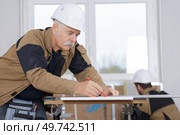 senior carpenter sanded wooden materials. Стоковое фото, агентство Ingram Publishing / Фотобанк Лори