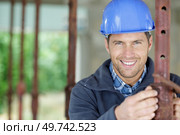 male builder setting level on acrow prop. Стоковое фото, агентство Ingram Publishing / Фотобанк Лори