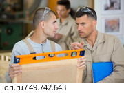 two men in workwear in a carpenters workshop. Стоковое фото, агентство Ingram Publishing / Фотобанк Лори