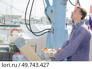 Man operating crane on quayside. Стоковое фото, агентство Ingram Publishing / Фотобанк Лори