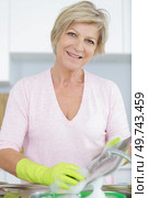portrait of a mature woman washing dishes. Стоковое фото, агентство Ingram Publishing / Фотобанк Лори