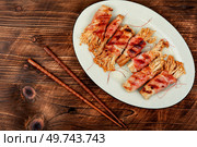 Bacon rolls stuffed with enoki mushroom. Bacon wrapped mushroom. Flat lay with copy space.. Enoki mushroom roll appetizer fried in bacon. Стоковое фото, агентство Ingram Publishing / Фотобанк Лори