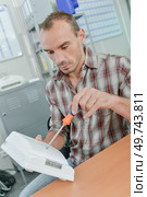 Man with screwdriver and white box. Стоковое фото, агентство Ingram Publishing / Фотобанк Лори