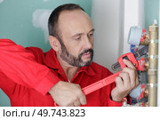 plumber assembles a new water connection to the sink. Стоковое фото, агентство Ingram Publishing / Фотобанк Лори