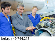 Man trying to lever aircraft component. Стоковое фото, агентство Ingram Publishing / Фотобанк Лори