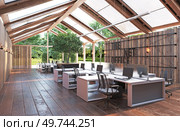 A large open office space with wooden floors . The space is filled with desks and chairs, and there are several potted plants scattered throughout the room. A large open office space with wooden floors. Стоковое фото, агентство Ingram Publishing / Фотобанк Лори