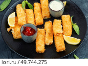 Crumbed fried fish fingers in sticks with sauce. Close up.. Breaded fish fingers with lemon, fish sticks. Стоковое фото, агентство Ingram Publishing / Фотобанк Лори