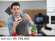 young male food blogger recording video in kitchen. Стоковое фото, агентство Ingram Publishing / Фотобанк Лори