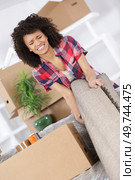 young woman suffering from backache while moving carpet. Стоковое фото, агентство Ingram Publishing / Фотобанк Лори