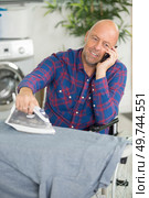 happy man in a wheelchair ironing. Стоковое фото, агентство Ingram Publishing / Фотобанк Лори