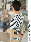 son and father embracing male holding gift box receiving greetings. Стоковое фото, агентство Ingram Publishing / Фотобанк Лори