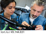 positive guy and girl hiring bikes ot rental store. Стоковое фото, агентство Ingram Publishing / Фотобанк Лори