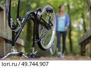 lady carrying wheel returning to upturned bicycle. Стоковое фото, агентство Ingram Publishing / Фотобанк Лори