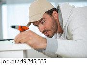 process of drilling screws with an electric screwdriver. Стоковое фото, агентство Ingram Publishing / Фотобанк Лори