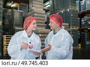 two busy coleagues looking at the clipboard with assignments. Стоковое фото, агентство Ingram Publishing / Фотобанк Лори