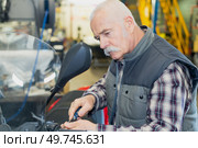 senior mechanic fixing a motorbike. Стоковое фото, агентство Ingram Publishing / Фотобанк Лори