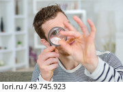 man looking at ring through magnifying glass. Стоковое фото, агентство Ingram Publishing / Фотобанк Лори