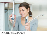 female plumber fixing a kitchen sink. Стоковое фото, агентство Ingram Publishing / Фотобанк Лори