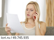 frustrated young woman with letter and phone. Стоковое фото, агентство Ingram Publishing / Фотобанк Лори