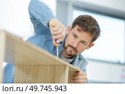 a male carpenter tightening screws. Стоковое фото, агентство Ingram Publishing / Фотобанк Лори