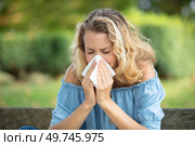 woman with with allergy symptom blowing nose. Стоковое фото, агентство Ingram Publishing / Фотобанк Лори