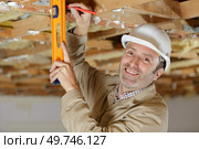 closeup of male carpenter using level on wood structure. Стоковое фото, агентство Ingram Publishing / Фотобанк Лори