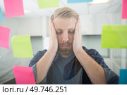 overwhelmed man surrounded by colourful post-its. Стоковое фото, агентство Ingram Publishing / Фотобанк Лори