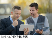 manager of a factory showing tablet to worker. Стоковое фото, агентство Ingram Publishing / Фотобанк Лори