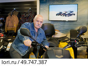 senior man by trike in showroom. Стоковое фото, агентство Ingram Publishing / Фотобанк Лори