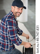 electrician with extension cord reel. Стоковое фото, агентство Ingram Publishing / Фотобанк Лори
