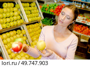a young woman contemplating apples. Стоковое фото, агентство Ingram Publishing / Фотобанк Лори