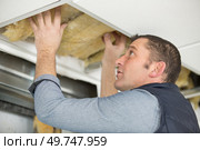 caucasian man fixes ceiling skirting. Стоковое фото, агентство Ingram Publishing / Фотобанк Лори