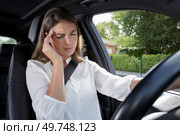 female driver wincing from a headache. Стоковое фото, агентство Ingram Publishing / Фотобанк Лори