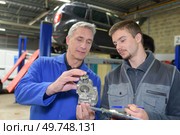 student with instructor repairing a car during apprenticeship. Стоковое фото, агентство Ingram Publishing / Фотобанк Лори
