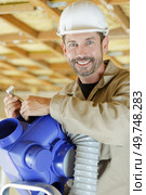 friendly smiling male worker holding electrical connections for ventilation system. Стоковое фото, агентство Ingram Publishing / Фотобанк Лори