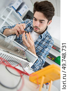 portrait of a young man fixing radiator. Стоковое фото, агентство Ingram Publishing / Фотобанк Лори