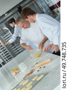 experienced baker teaching male apprentice. Стоковое фото, агентство Ingram Publishing / Фотобанк Лори
