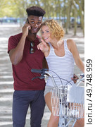 woman pointing at a friend on the phone with bicycles. Стоковое фото, агентство Ingram Publishing / Фотобанк Лори