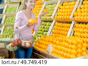 a woman is choosing oranges. Стоковое фото, агентство Ingram Publishing / Фотобанк Лори